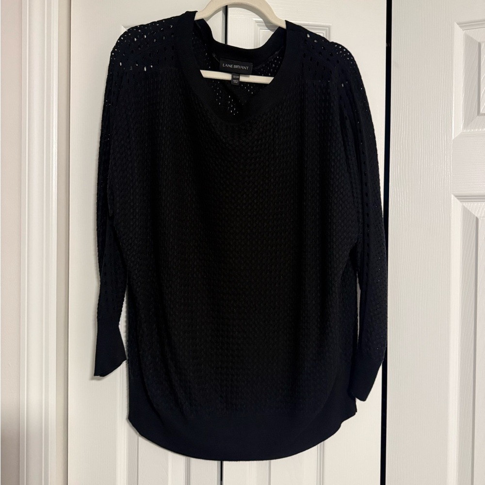 Staple black sweater with varying hole cutout design.